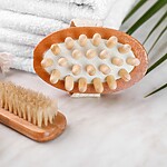 Dry Brushing for Beginners: A 3-Minute Routine for Glowing Skin Wooden dry brushes and a massage brush placed beside folded white towels on a clean bathroom counter.