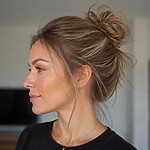 Woman with fine hair wearing a loose textured messy bun with soft face-framing pieces for added volume.