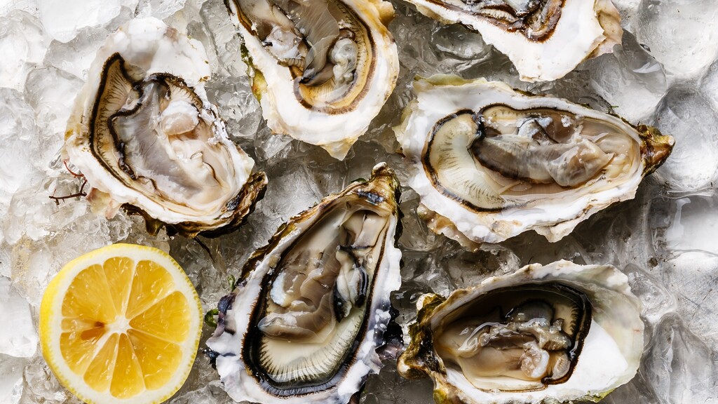 Fresh oysters on crushed ice with a lemon half.