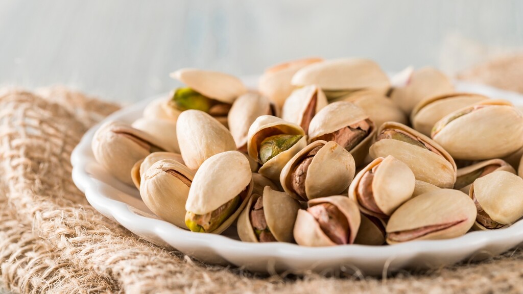 Plate of in-shell pistachios on a burlap cloth