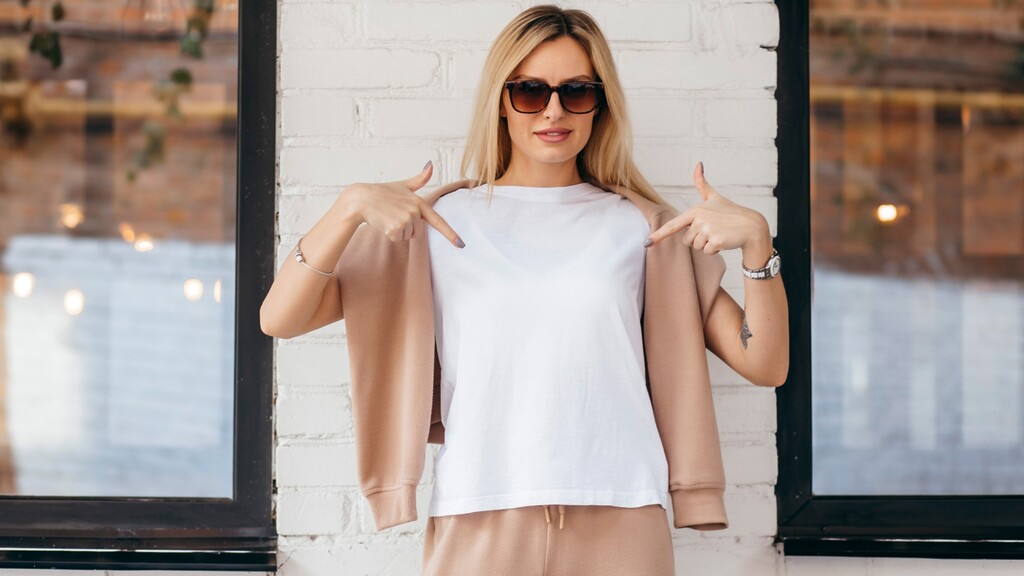Woman pointing to a plain white t-shirt with no visible logos.