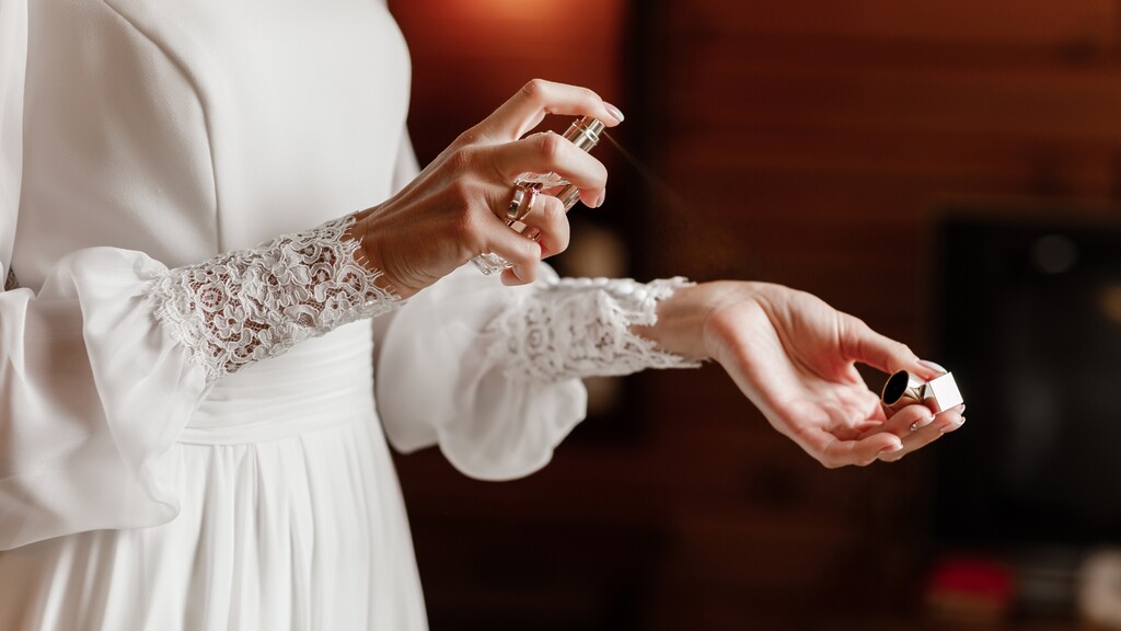 Woman spraying perfume onto her wrist for a subtle fragrance application.