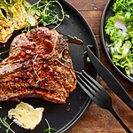 The Keto Diet for Diabetes: A Realistic Weight Loss Guide Grilled pork chop with roasted bok choy, herbs, soft cheese, and a side green salad on a wooden table.