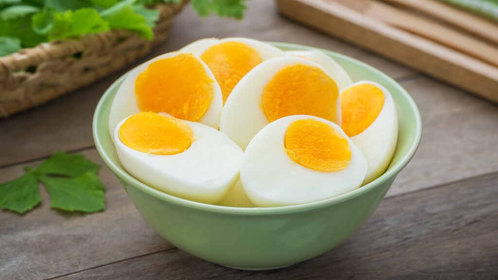 Hard-boiled eggs sliced in half in a green bowl.