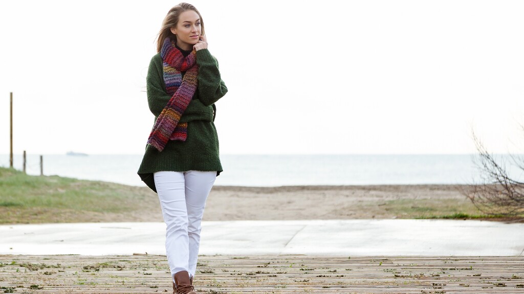Woman walking outdoors in cool weather, showing the need to protect skin from wind and cold.