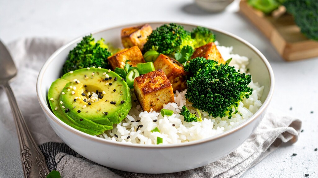 Tofu rice bowl with broccoli, avocado, sesame seeds, and green onions.