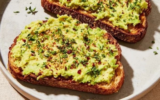 Avocado toast with hard boiled egg and chili flakes for a healthy breakfast.