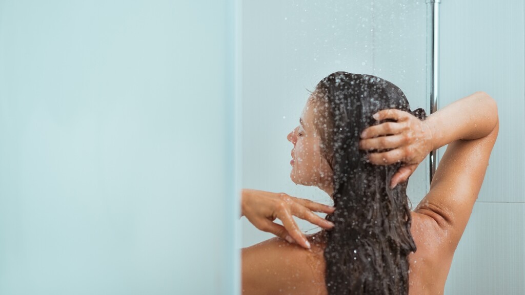 Woman taking a warm evening shower to support a calming bedtime routine.