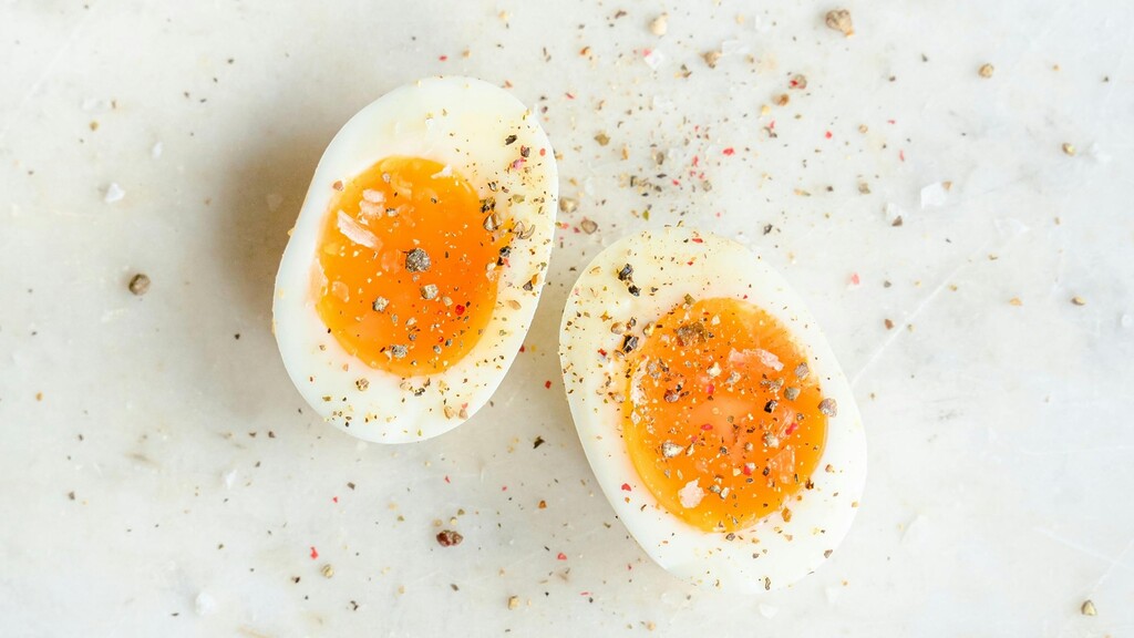 Two halved hard-boiled eggs seasoned with salt and pepper.