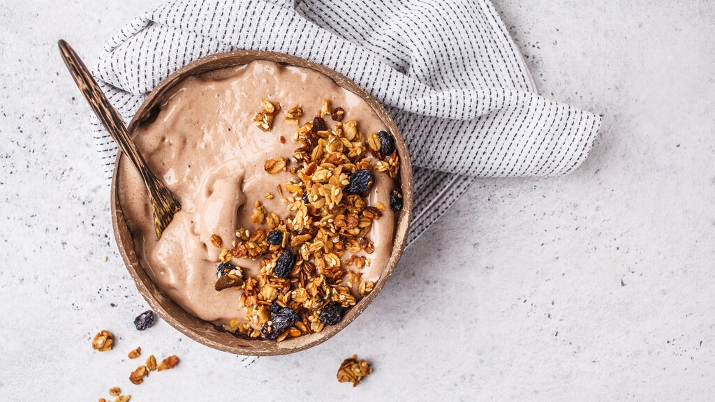 Smoothie bowl topped with granola and raisins, showing a healthy-looking breakfast that can be calorie dense.