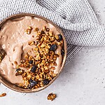 Smoothie bowl topped with granola and raisins, showing a healthy-looking breakfast that can be calorie dense.
