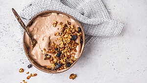 Smoothie bowl topped with granola and raisins, showing a healthy-looking breakfast that can be calorie dense.