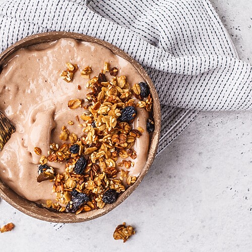 Smoothie bowl topped with granola and raisins, showing a healthy-looking breakfast that can be calorie dense.